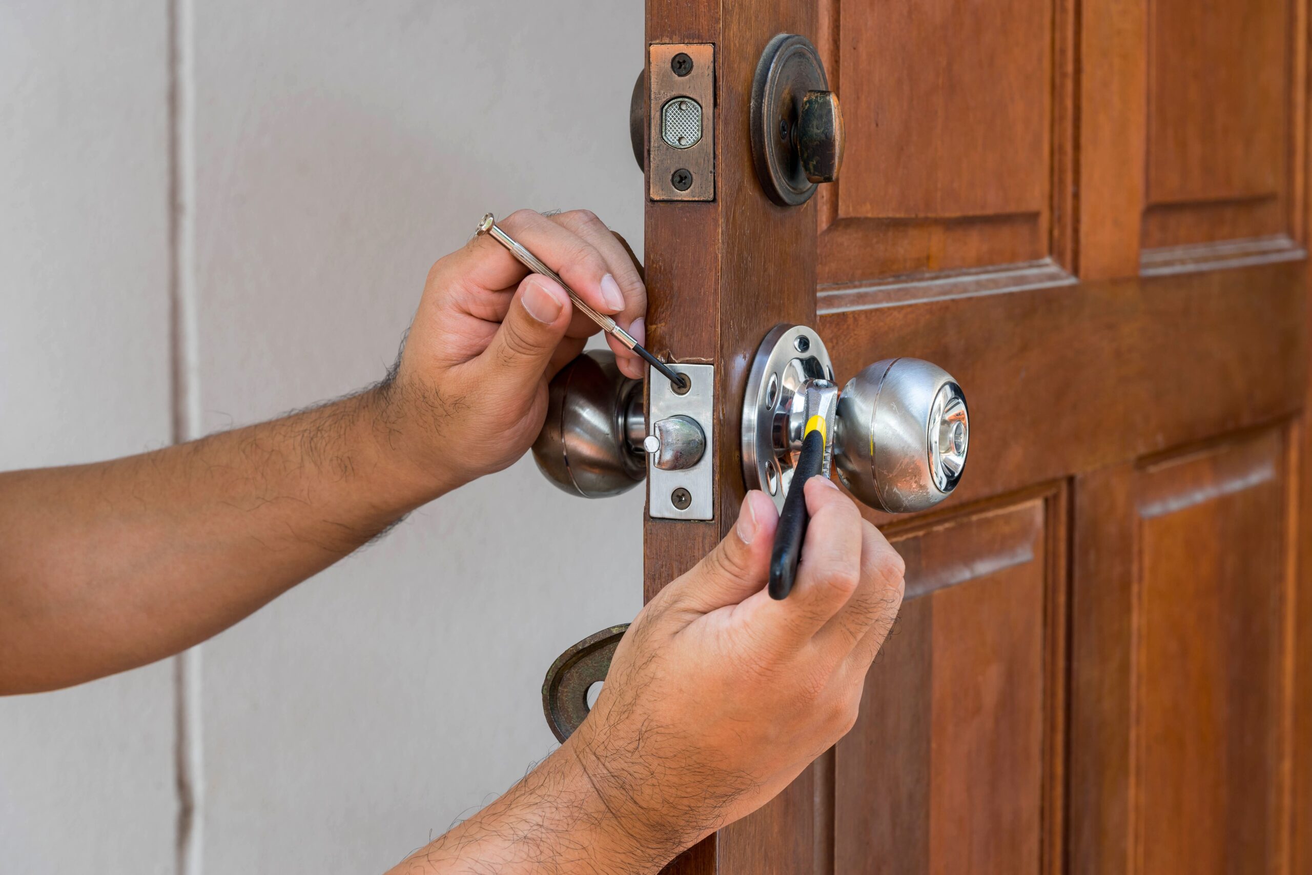 Person's hands installing doorknob and hardware.